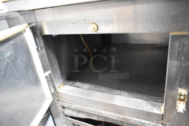 Leader LB72 stainless steel 3-door work top cooler, commercial casters, showing interior storage; 115 volts, 1 phase.