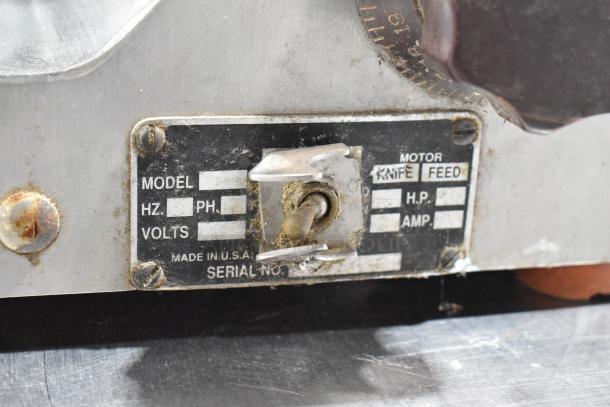 Globe 500 meat slicer label, shows missing carriage. Features 115V, 1 phase electrical specs. Visible wear and rust.