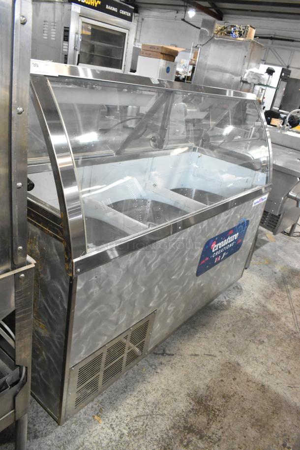 Metal ice cream dipping cabinet with bucket collars, stainless steel exterior, clear top display, used condition, visible minor wear.