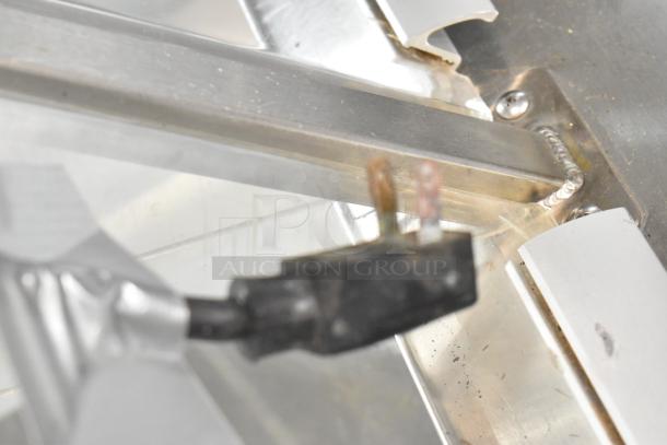 Metal commercial ice cream dipping cabinet with bucket collars, visible electrical plug, clean metal finish.