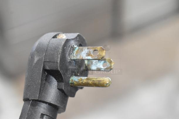 A close-up of a corroded electrical plug, unrelated to the Cleveland stainless steel braising pan.