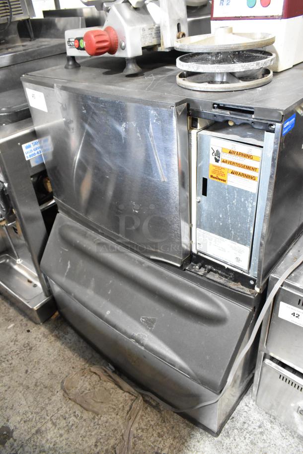 Manitowoc SD0302A stainless steel ice head on commercial bin, 115V, 1 phase, visible wear, warning labels present.