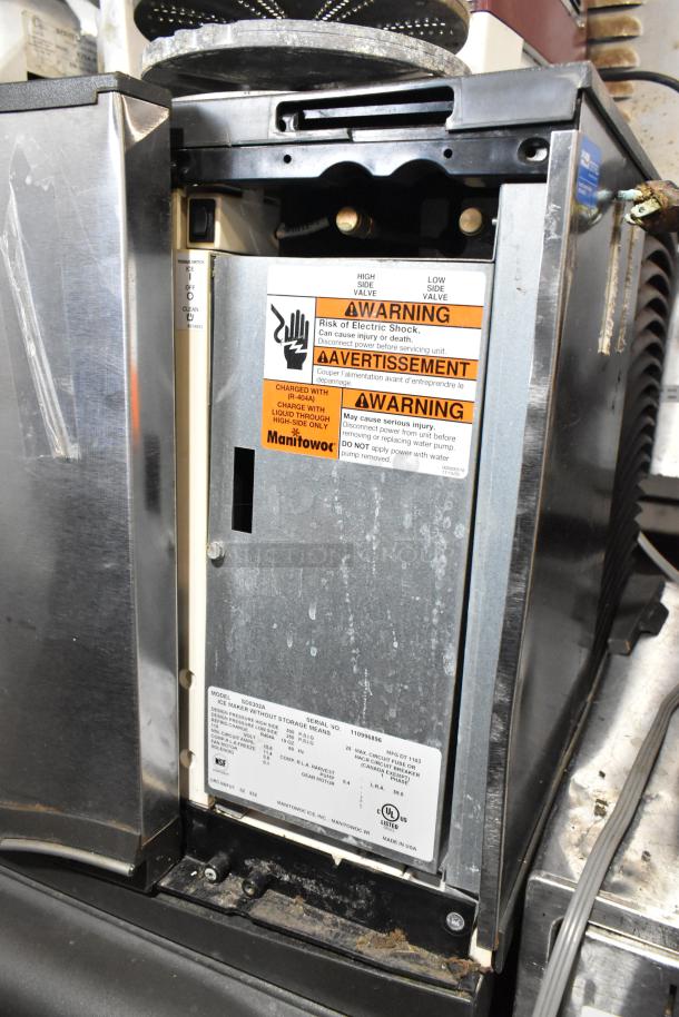 Manitowoc SD0302A stainless steel ice head on commercial bin. Features visible warning labels. 115 volts, 1 phase.