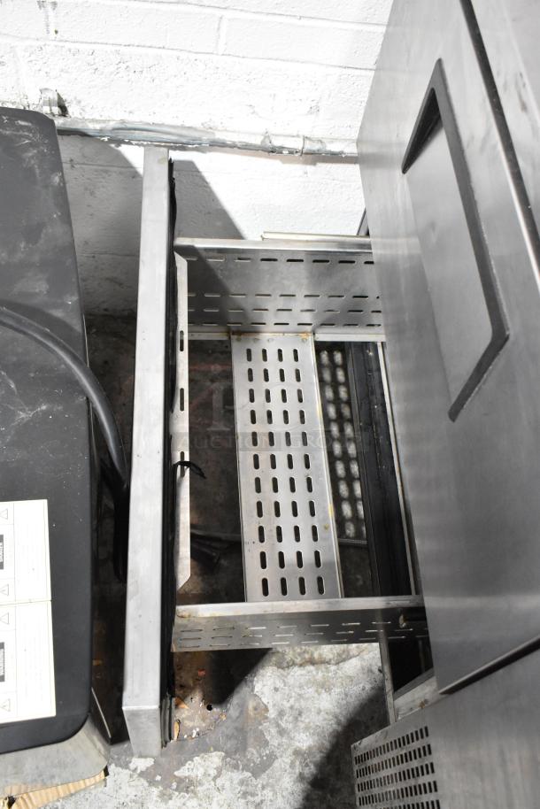 True stainless steel 2-drawer undercounter cooler on casters, showing interior shelves. 115V, 1 phase. Commercial grade.