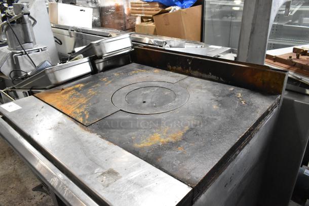 Stainless steel commercial gas-powered single burner French top range with two under shelves, on commercial casters. Used condition.