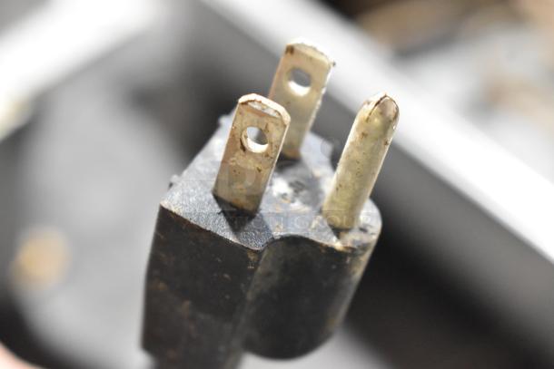 Close-up of a plug for Continental F412502 metal evaporator tray, 120V, 1 phase. Features signs of wear.