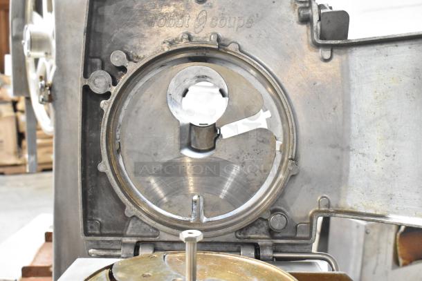 Robot Coupe CL52 commercial food processor, metal casing, slicing blade visible. 120 volts, 1 phase, with visible branding.