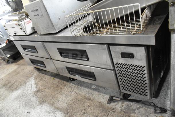 Stainless steel commercial chef base with 4 drawers, on casters. Powered by 115 volts, 1 phase. Visible wear on surface.