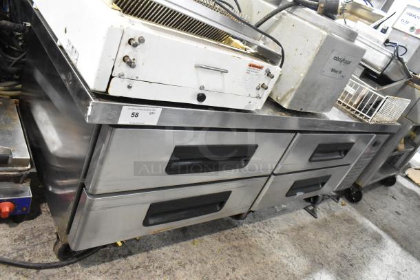 Stainless steel commercial 4-drawer chef base with commercial casters, 115 volts, 1 phase, showing some wear.
