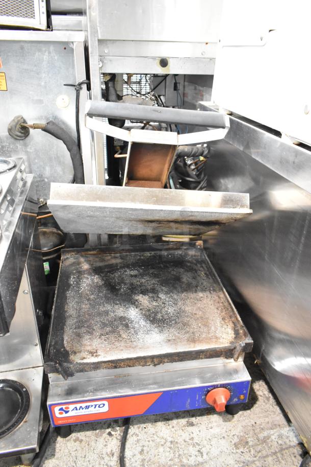 2021 Ampto SSGL metal countertop panini press, 120V, 1 phase. Visible wear, Ampto logo, single adjustment knob.