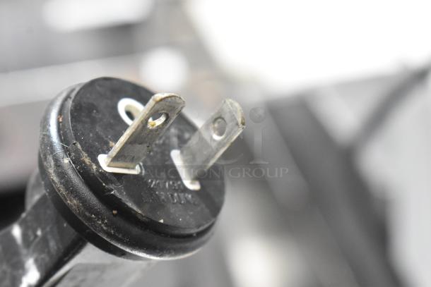 Robot Coupe R602 V.V. food processor plug detail, showing metal prongs. 120V, single phase. Some wear visible.