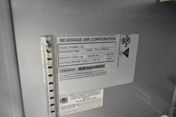 Beverage Air SPE48HC-12C stainless steel sandwich salad prep table; features model tag with specs; on commercial casters.