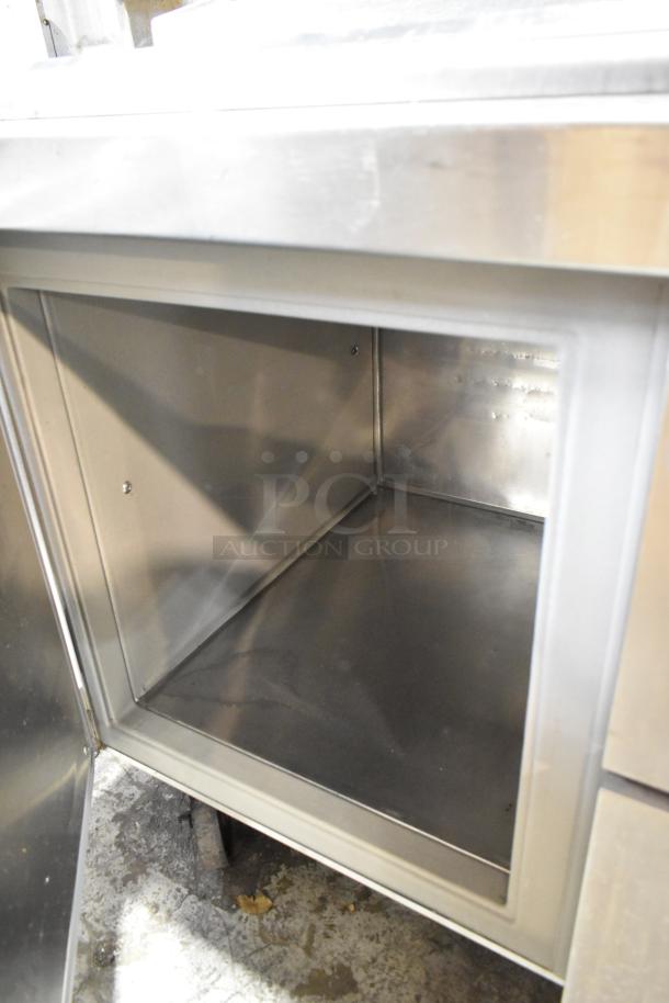 Randell 51395PR stainless steel pizza prep table with open compartment, 2 drawers, 2 doors, on commercial casters.