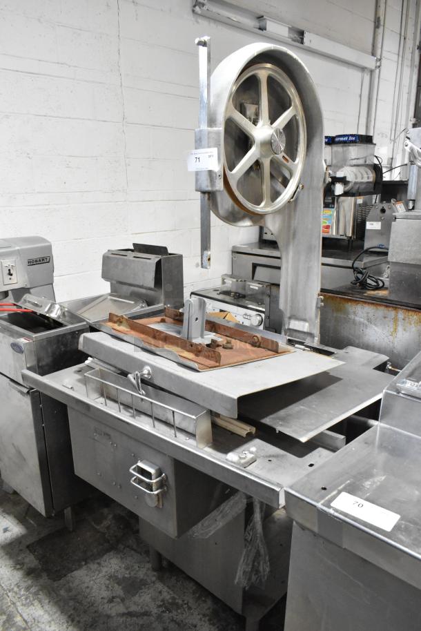 Metal commercial floor-style meat saw, sturdy construction, slightly worn, includes blade guard, model tag visible.