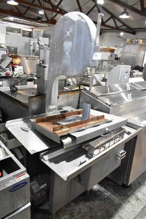 Metal Commercial Floor Style Meat Saw, sturdy construction, used condition with signs of wear, includes cutting guide and platform.