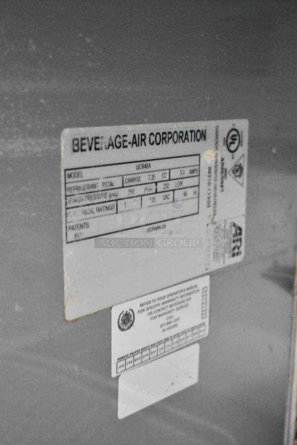 Beverage Air UCR48A stainless steel 2-door undercounter cooler with commercial casters. Label shows model and specifications.