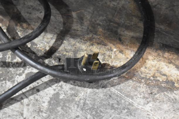 Power cord for Beverage Air SPE48-18M Prep Table, 115 volts. Shows standard three-prong plug on a textured surface.