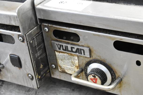 Vulcan stainless steel commercial gas griddle with control knob. Shows signs of use. Vulcan branding visible on front.