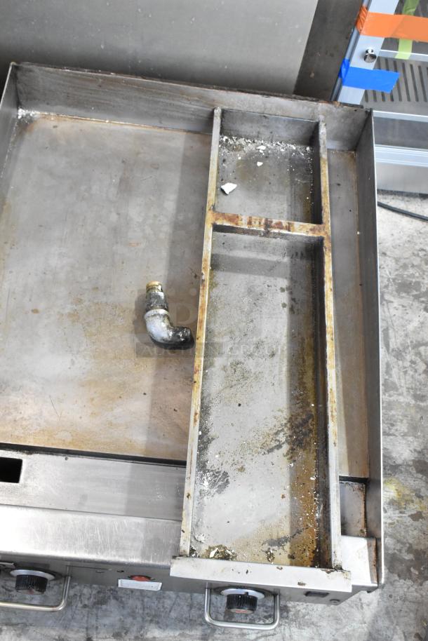 Vulcan stainless steel commercial gas-powered flat top griddle, countertop model, used condition with visible wear.