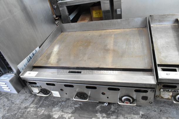 Vulcan stainless steel commercial countertop gas griddle, with control knobs and label. Slight signs of use.