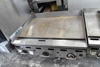 Vulcan stainless steel commercial countertop gas griddle, with control knobs and label. Slight signs of use.