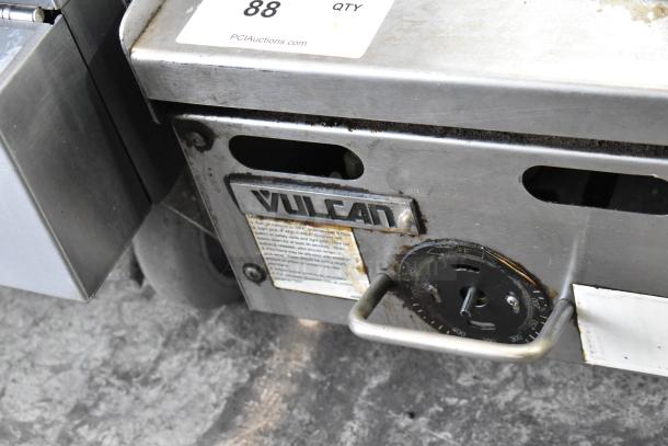 Vulcan stainless steel countertop gas griddle, commercial use, visible wear, branded emblem, and dial controls shown.