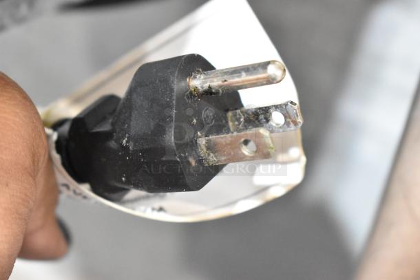 Close-up of a three-prong power plug connected to a L&J NY commercial convection oven. Plug appears slightly worn.