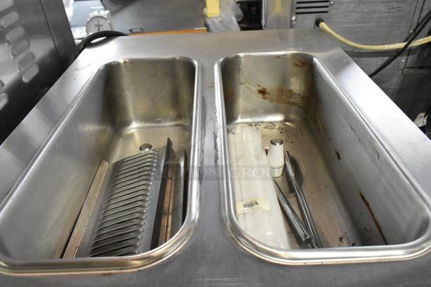 Taylor C723-33 stainless steel 2-flavor soft serve machine basin area, water cooled, on commercial casters, 208-230V, 3 phase.