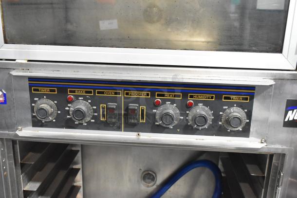Nu Vu SUB-123 stainless steel electric oven proofer, 240V 3-phase, on casters, missing lower door, model controls visible.