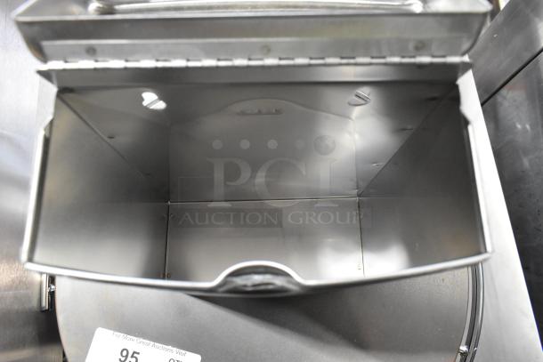 Bobrick stainless steel trash can in excellent condition, featuring a hinged lid and smooth inner surface. Auction tag visible.