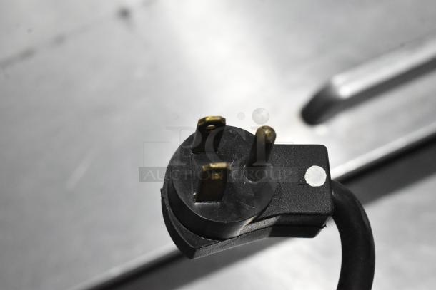 Close-up image of a three-prong plug from a Beverage Air SPE48-18M-HMP sandwich prep table, showing a secure connection.