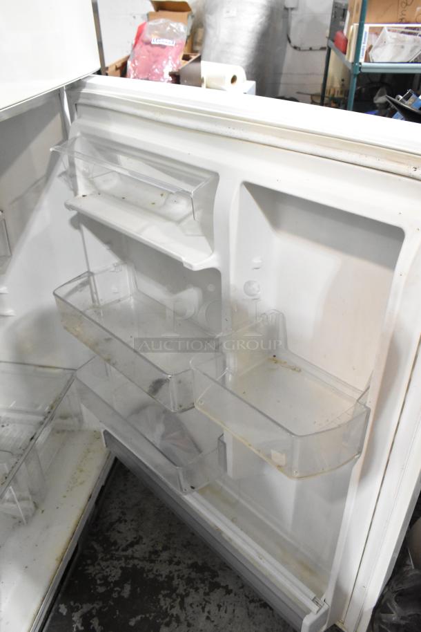 Whirlpool WRT511SZDW00 reach-in cooler interior, with shelving and freezer compartments visible, showing signs of wear.