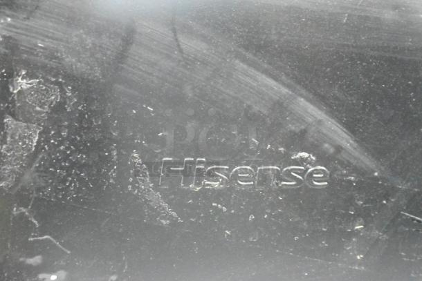 Hisense mini cooler close-up showing surface wear and embossed logo, 115 volts, ideal for compact cooling needs.