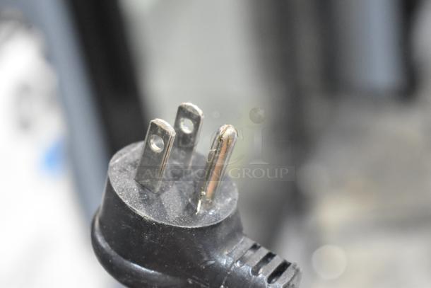Close-up of a power plug for the 2021 True GDM-12-HC-LD commercial cooler, showing three-pronged 115V connection.