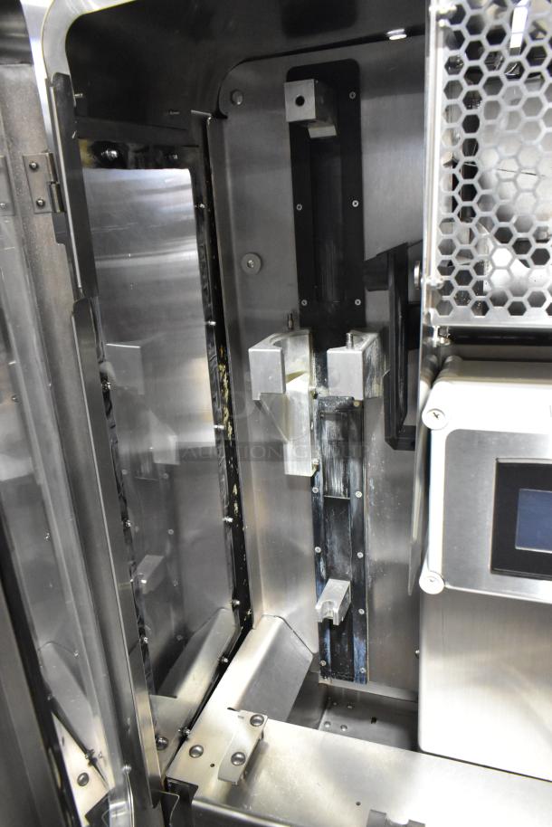 JBT Fresh N Squeeze stainless steel commercial citrus juicer interior, showcases metal components; mounted on commercial casters.