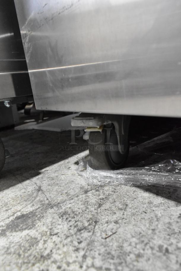 JBT Fresh N Squeeze stainless steel citrus juicer on commercial casters, 115 volts, floor style. Visible wear on casters.