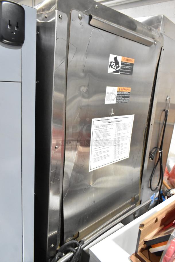 JBT Fresh N Squeeze stainless steel commercial citrus juicer, floor style with casters. 115V, 1-phase. Warning and usage labels visible.