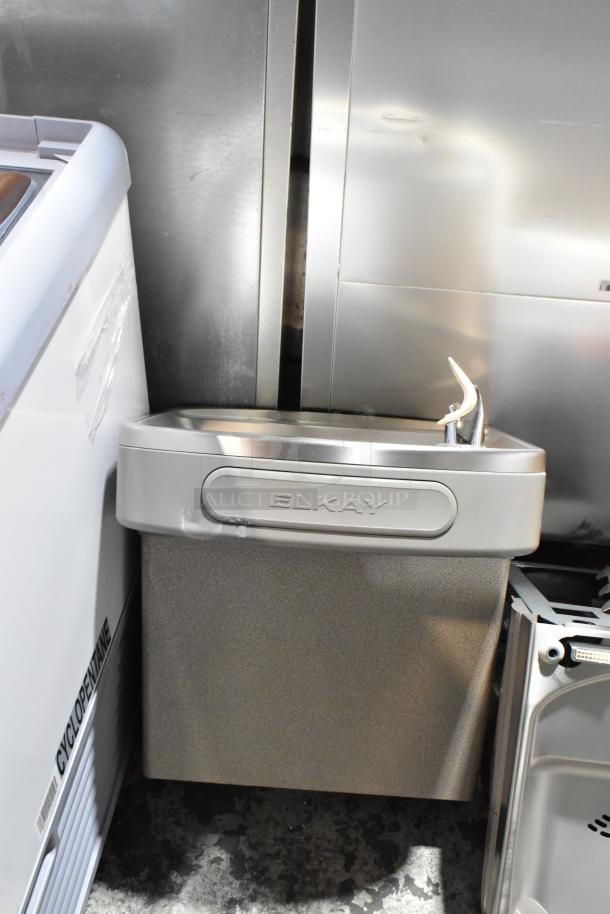 BRAND NEW Elkay stainless steel 2-tier water fountain with bottle filler, 115 volts, minor dents visible.