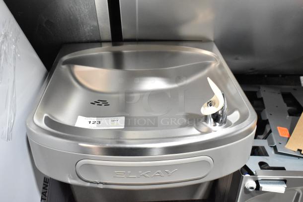 Brand new Elkay stainless steel water fountain, 2-tier with bottle filler, 115V, slight scratches and dents. Model label visible.