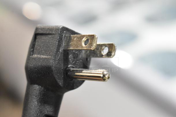 Close-up of a power plug for the Avantco 360ADC12N ice cream cabinet, 115 volts, showing prongs and grounding pin.