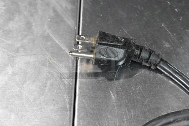 Close-up of a power plug on a metal surface, part of Vita-Mix VM0145 countertop blender base, 120 volts, 1 phase.