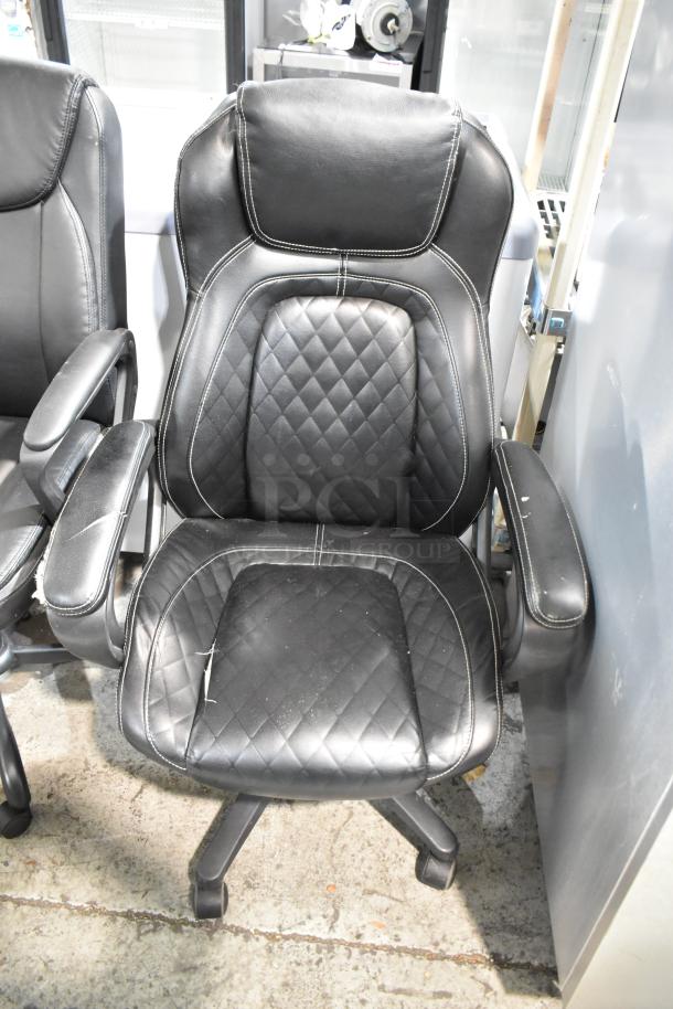 Two black leather office chairs on casters, featuring quilted seat and backrest, minor wear visible, adjustable armrests.