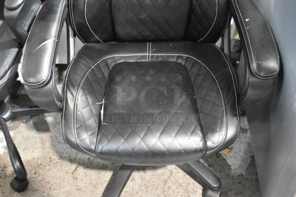 Two black office chairs on casters, worn condition with visible scratches and stitching. Bid doubles for both chairs.