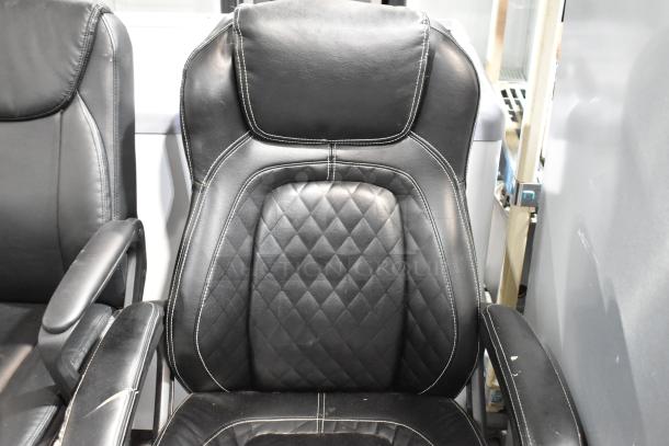 Black leather office chairs with caster wheels, featuring diamond-pattern upholstery and cushioned armrests. Slight surface wear.