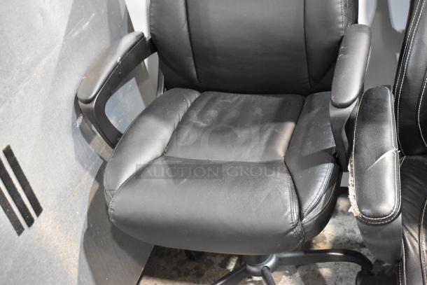 Two black office chairs on casters, leather, showing signs of wear, with padded armrests and adjustable height.