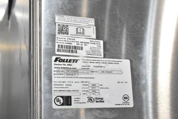 2024 Follett HMC1410WBT stainless steel ice head on Ice-O-Matic bin. Labels show model, voltage, refrigerant, and certifications.