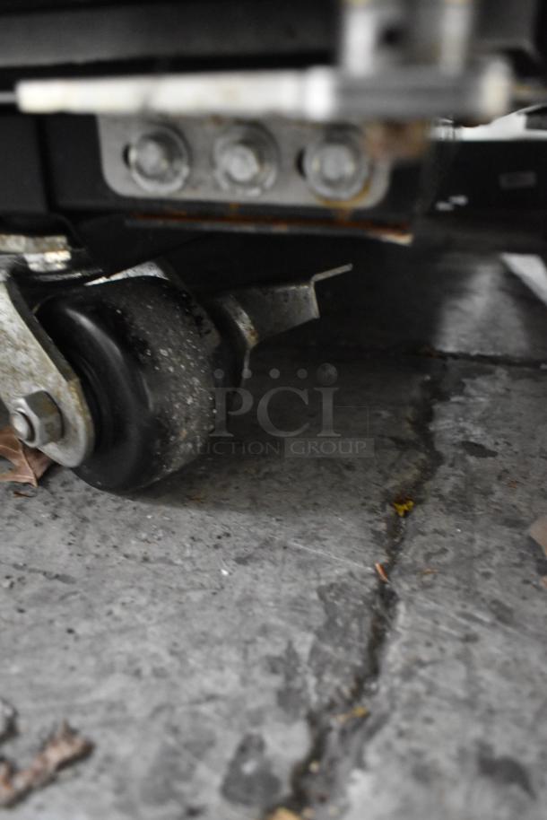 2023 True TG1R-1S-HC cooler caster wheel on concrete, showing poly-coated rack support. In used condition.