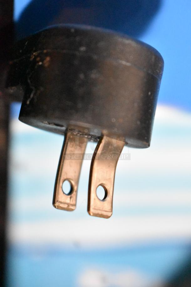 Close-up of an electrical plug for the Delfield 406-STAR2 cooler, showing metal prongs and a black casing.