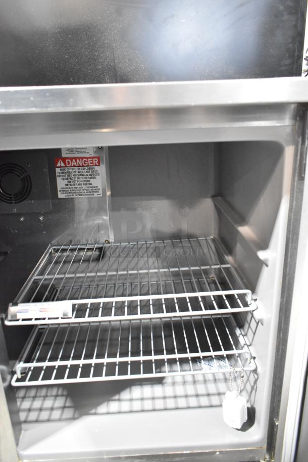 Delfield stainless steel 2-door undercounter cooler, 115 volts, 1 phase. Interior shelves and safety warning label visible.