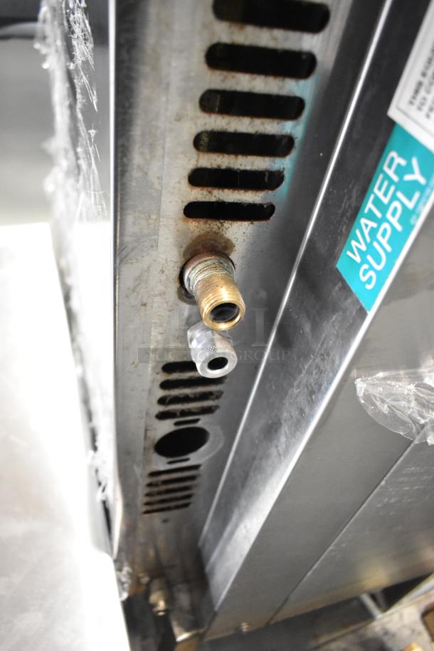 Baxter stainless steel mini rotating rack oven, water supply label visible, electric powered, commercial use, on double pan rack.